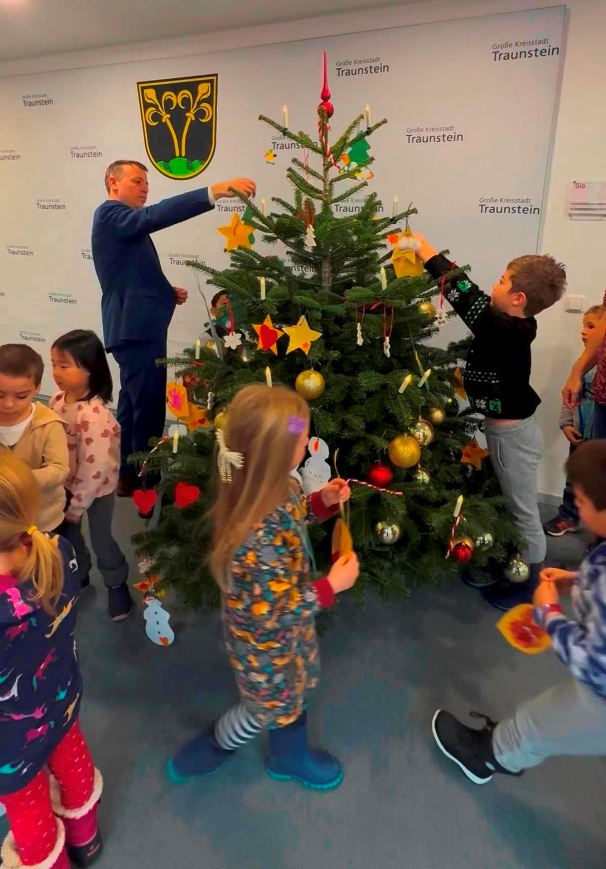 Kinder schmücken Christbaum im Rathaus