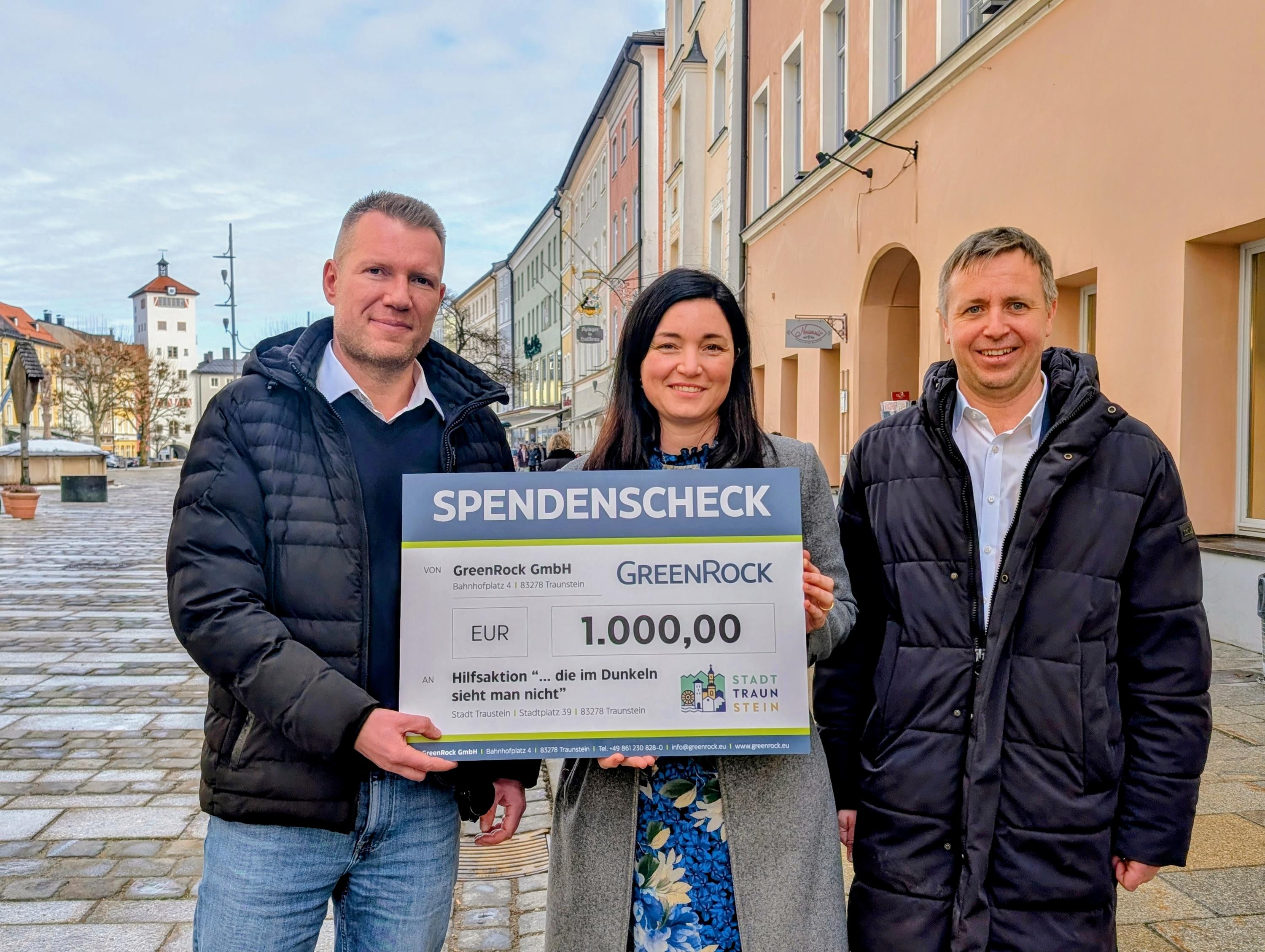 Dr.-Ing. Franz Hauk, Inhaber und Geschäftsführer der GreenRock Real Estate GmbH mit Unternehmenssitz in Traunstein, übergab einen Scheck in Höhe von 1.000 Euro an Veronika Hümmer, Schirmherrin der Hilfsaktion „… die im Dunkeln sieht man nicht“, und Oberbürgermeister Dr. Christian Hümmer. (Foto © Carola Westermeier / Große Kreisstadt Traunstein)