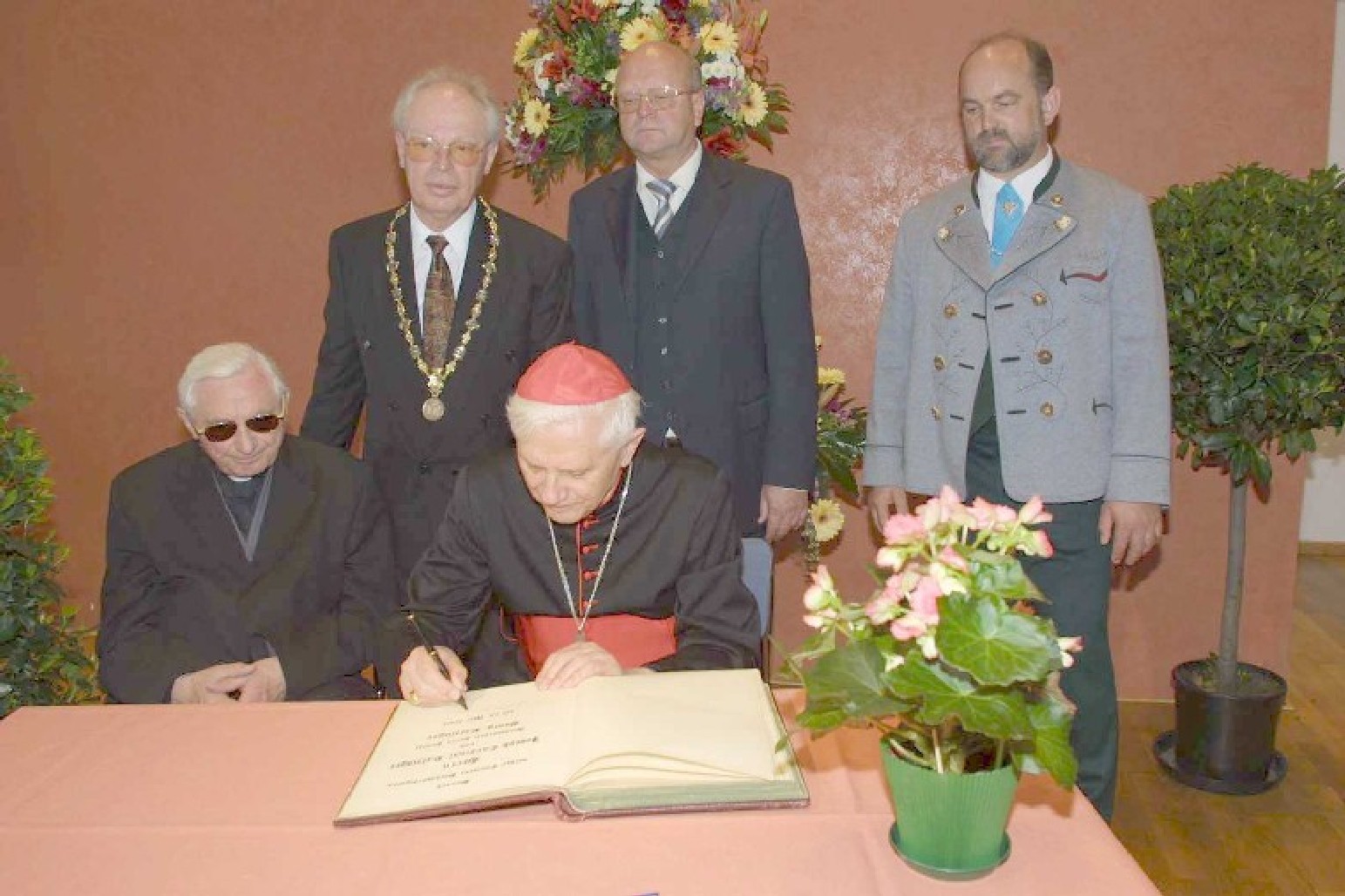 Eintrag in das Goldene Buch der Stadt beim Besuch 2002, neben Joseph sein Bruder Georg Ratzinger, hinten (von links): Bürgermeister Fritz Stahl, Landrat Hermann Steinmaßl, Surbergs Bürgermeister Josef Wimmer. (© Stadtarchiv Traunstein)