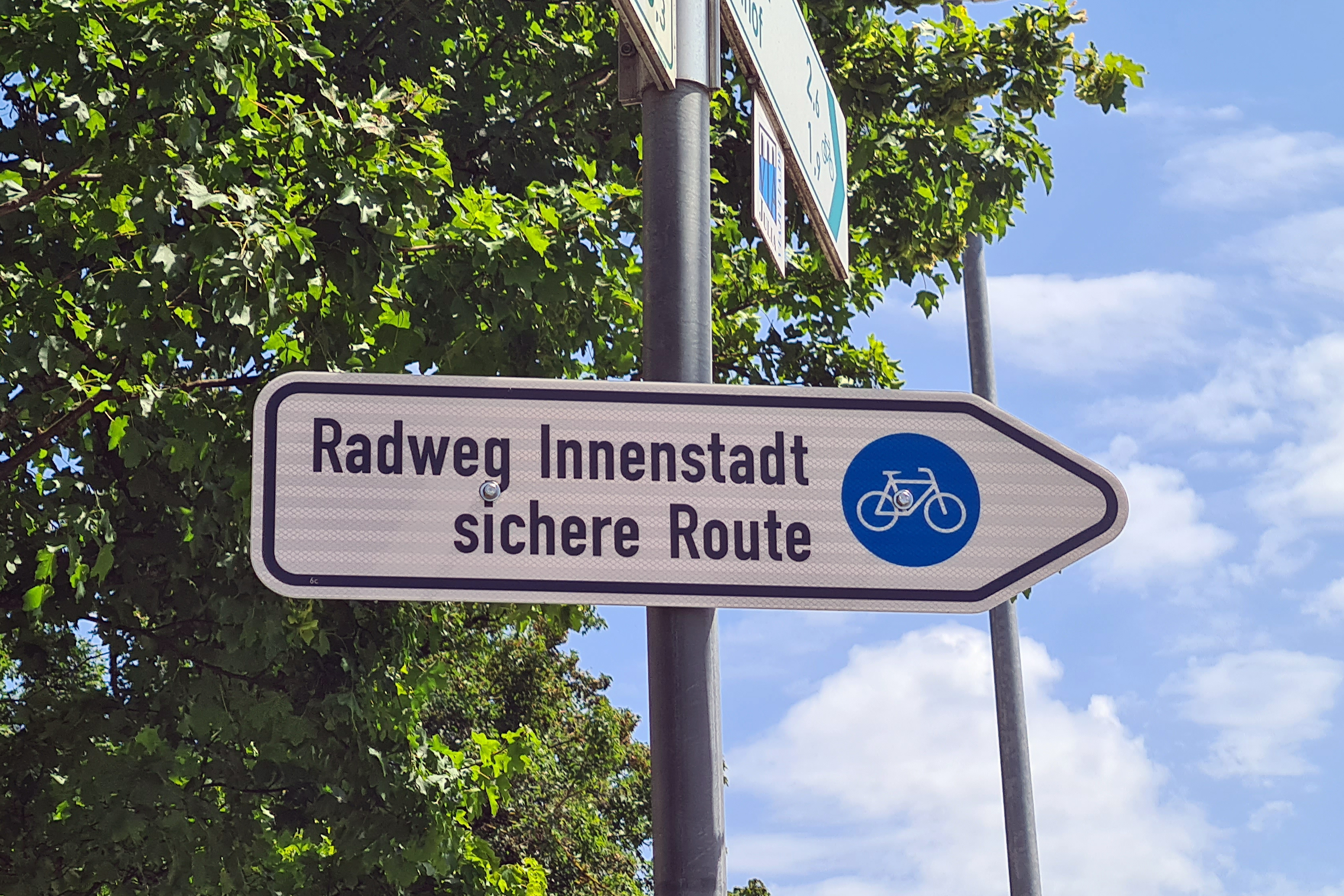 Die Radweg-Beschilderung im Traunsteiner Norden wurde ergänzt: So werden die Radfahrer, die aus Richtung Aiging kommen, nun auf Höhe des Waldfriedhofes auf ihrem Weg Richtung Innenstadt über die Querungshilfe und dann entlang der Wasserburger Straße geleitet. (Bild © Carola Westermeier / Große Kreisstadt Traunstein)