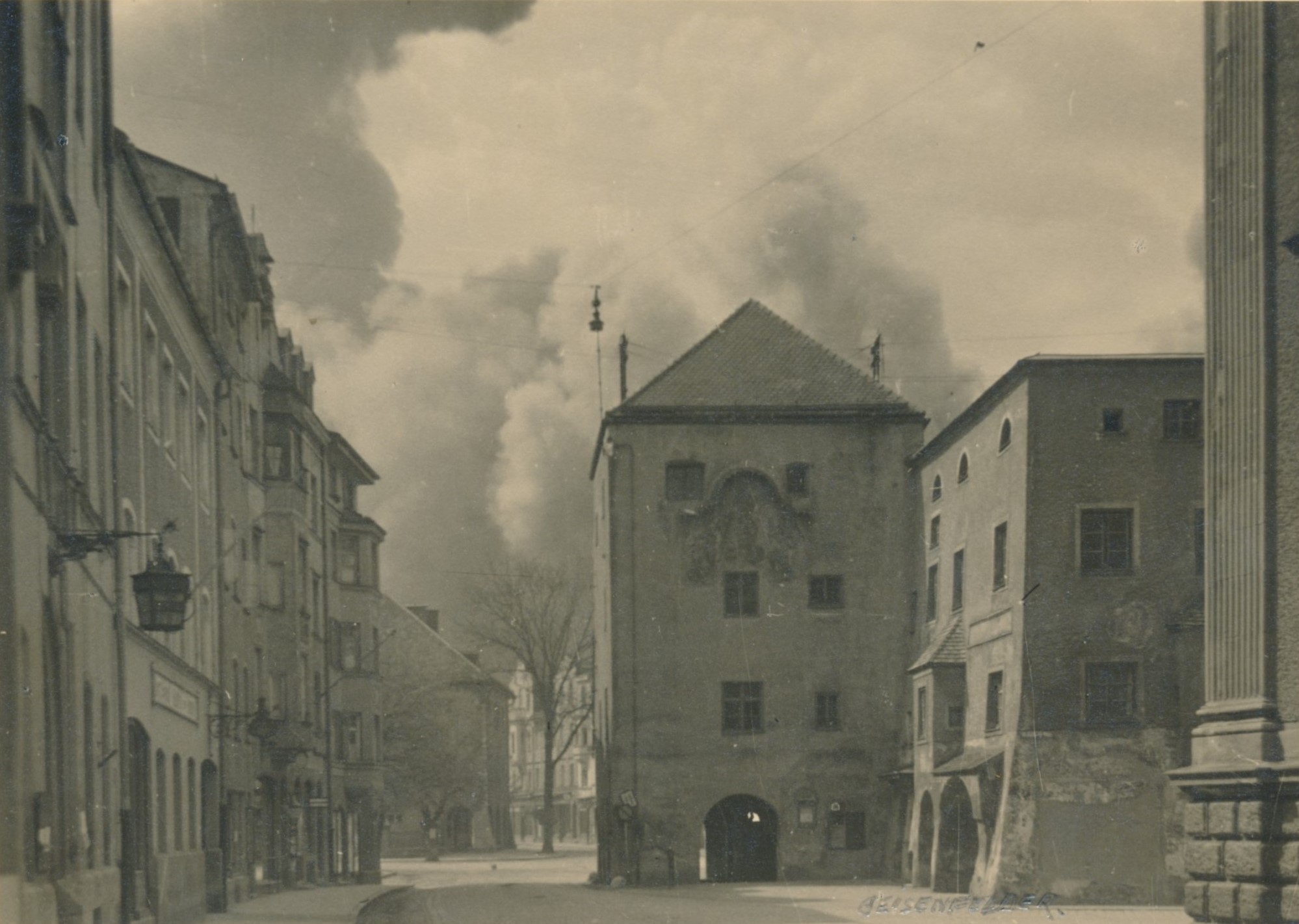 Staub und Rauch verdüsterten die menschleere Stadt Traunstein, als die Alliierten am 18. April 1945 gegen 15 Uhr den Bahnhof bombardierten. (Fotografie, Josef Geisenfelder, Traunstein
Stadtarchiv Traunstein, Bü 310) Leider haben wir keinen Alternativtext zu diesem Bild, aber wir arbeiten daran.